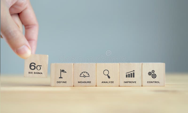 Hand pick up Six sigma icon on wooden cubes  standing on wood table with blue background, clean tone. The DMAIC Industrial technology quality control, industrial process improving and lean concept