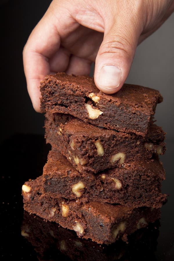 Hand Picking a Chocolate Brownie royalty free stock photo