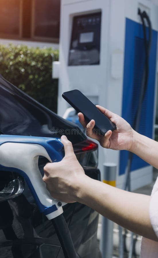 Hand Plugging in a Charger in an Electric Car Socket.Electric Car or Ev
