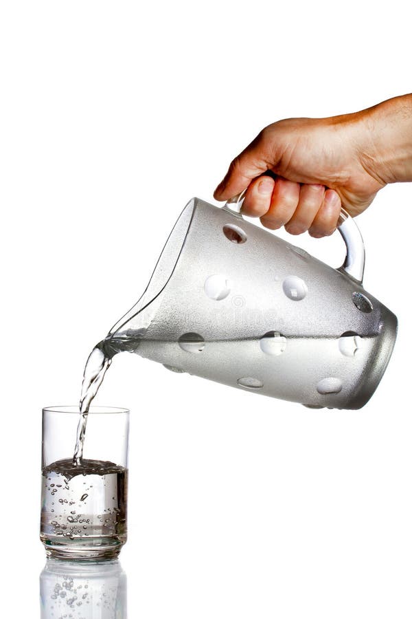 Hand pouring water from glass pitcher Stock Photo