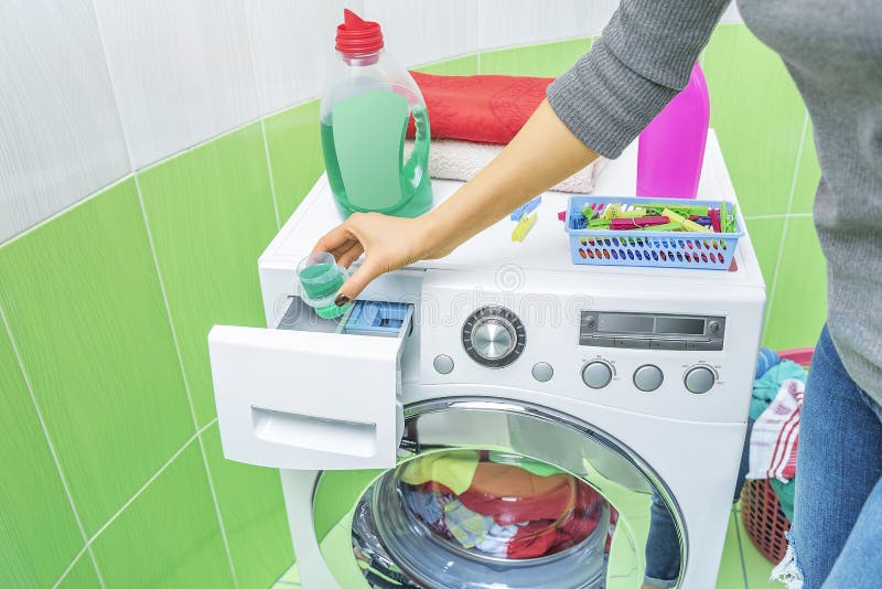 Hand Pours Liquid Powder into the Washing Machine. Stock Photo Image of domestic, conditioner