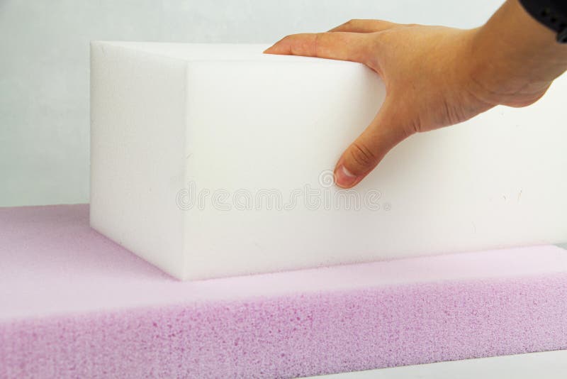 The hand presses on the surface of the rubber foam. Checking hardness and softness. Choosing the best type and quality stock images