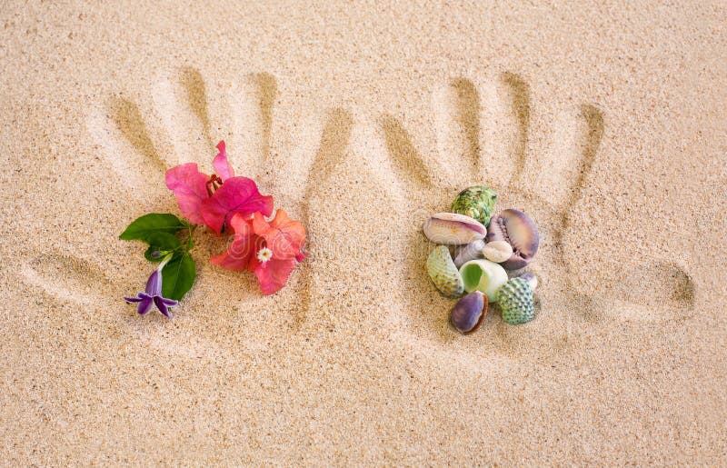 Hand Print on Sand with Flower and Shells arrangement, summer holiday concept