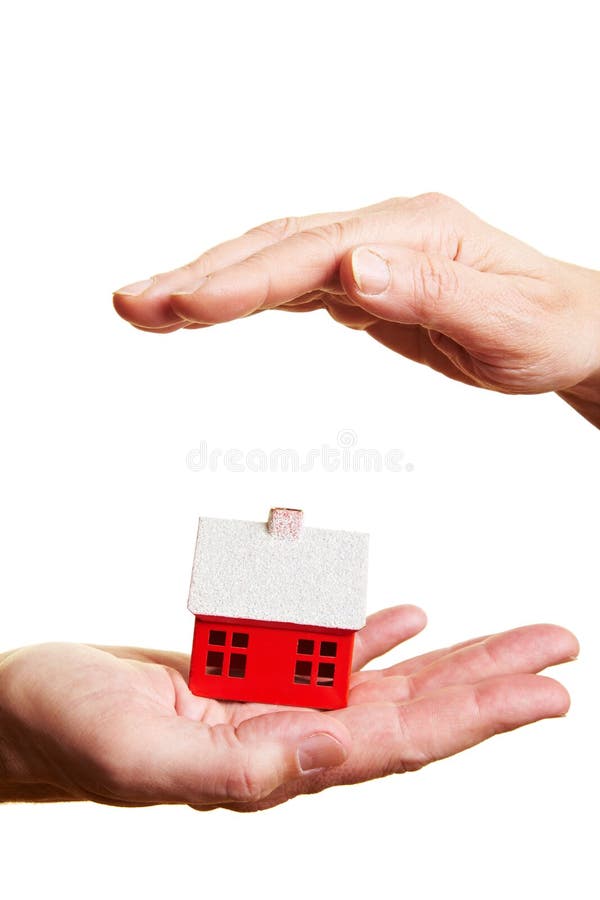 Hand protecting a small red miniature house. Hand protecting a small red miniature house