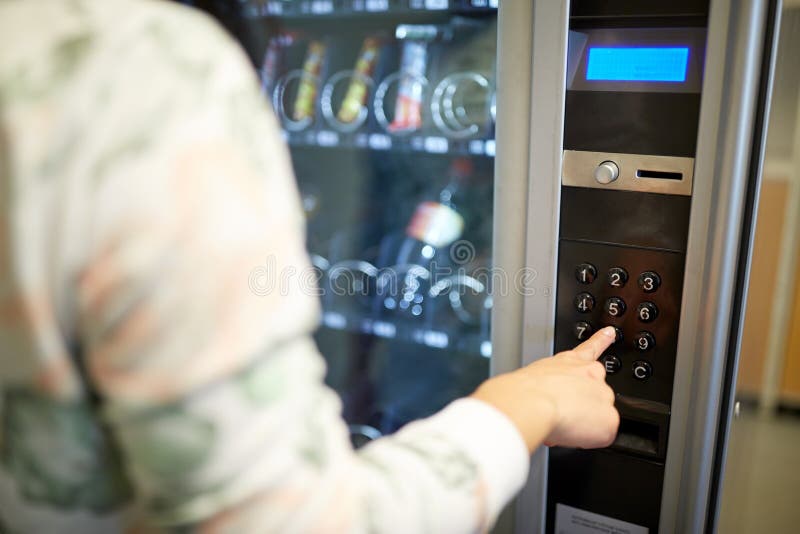 Hand pushing button on vending machine keyboard