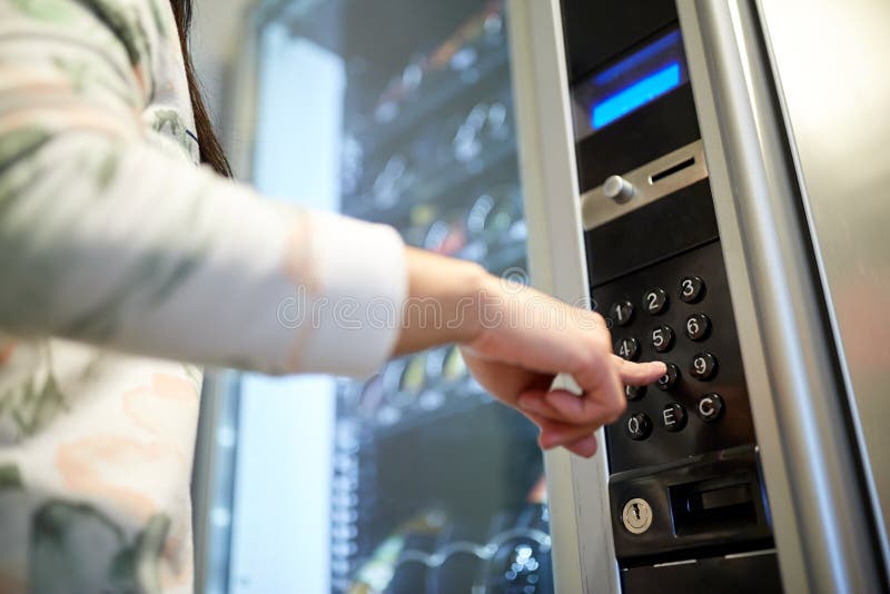 Hand pushing button on vending machine keyboard