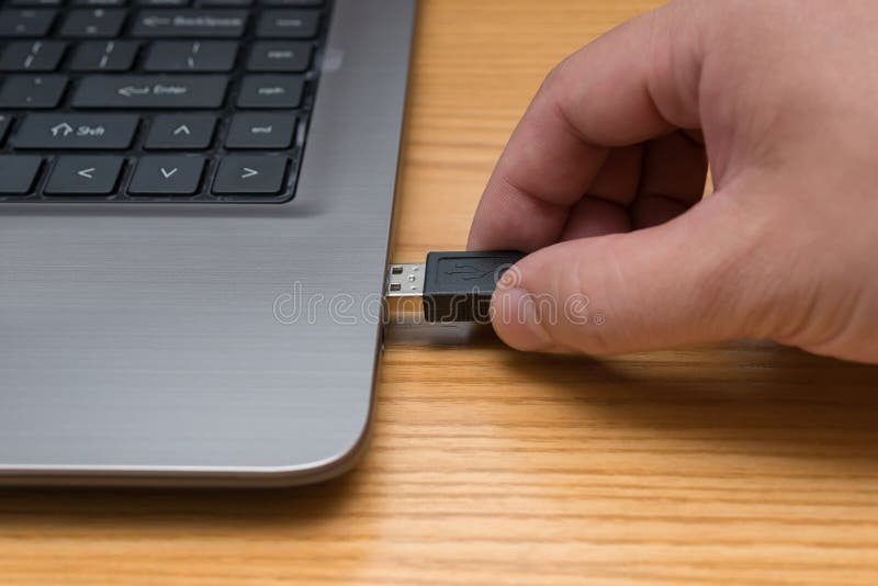 Hand putting a blue network connecting cable to laptop royalty free stock image