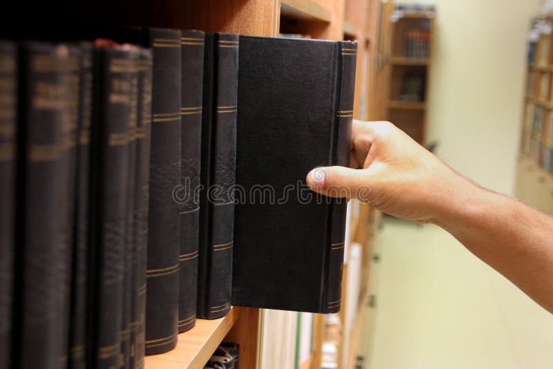 Hand reaching for book on a shelf