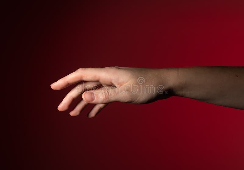 Hand reaching out, fingers gently stretching, pointing, showing subtle, graceful motion. Woman with royalty free stock photo