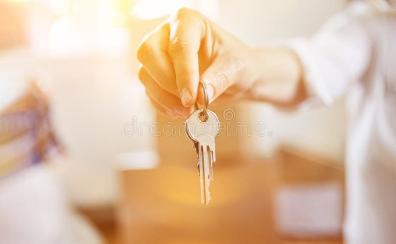 Hand of realtor with key at house handover