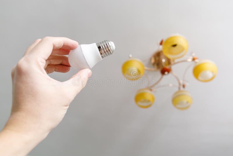 Hand Screwing New Lightbulb Into Ceiling Lamp Stock Image