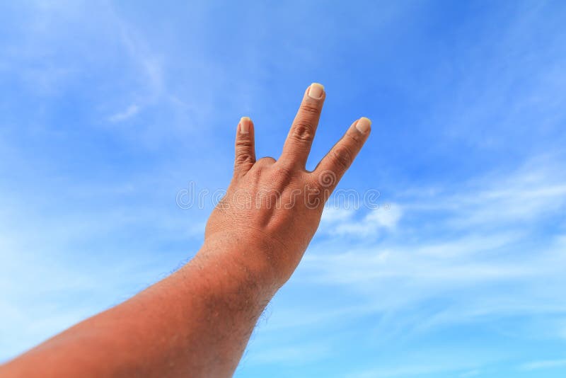 Hand show counting number three on sky background stock photo