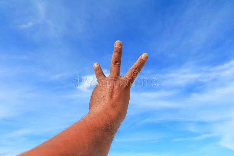 Hand show counting number three on sky background stock photo