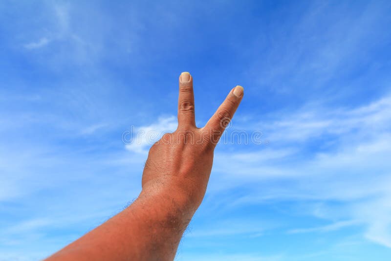 Hand show counting number two on sky background stock images