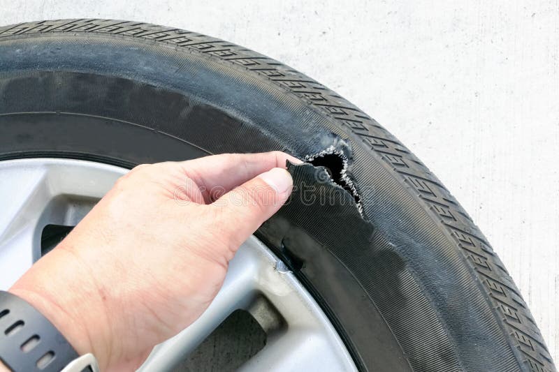 Hand Showing Flat Ruptured Damaged Tire Wheel with Rim Stock Image