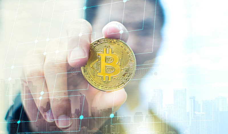 Hand som rymmer bitcoin med suddighetsbakgrund av affärsmannen royaltyfri fotografi Hand som rymmer bitcoin med suddighetsbakgrund av affärsmannen royaltyfri fotografi