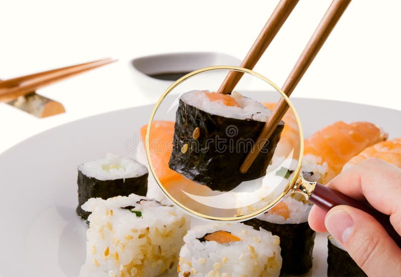 Hand som undersöker mycket noggrant sushi som tjänas som i platta till och med förstoringsglaset royaltyfria foton Hand som undersöker mycket noggrant sushi som tjänas som i platta till och med förstoringsglaset royaltyfria foton