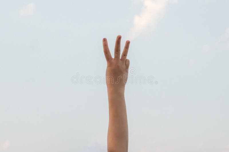 Hand doing, showing number three gesture symbol on bright blue summer sky nature background. Gesturing number 3. Number three in sign language. Third and counting three concepts. 3 finger up. Hand doing, showing number three gesture symbol on bright blue summer sky nature background. Gesturing number 3. Number three in sign language. Third and counting three concepts. 3 finger up