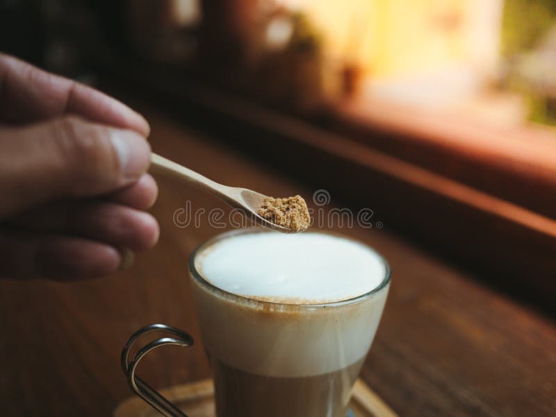 A Hand with a Spoon Pouring Sugar in a Coffee Cup Stock Image Image