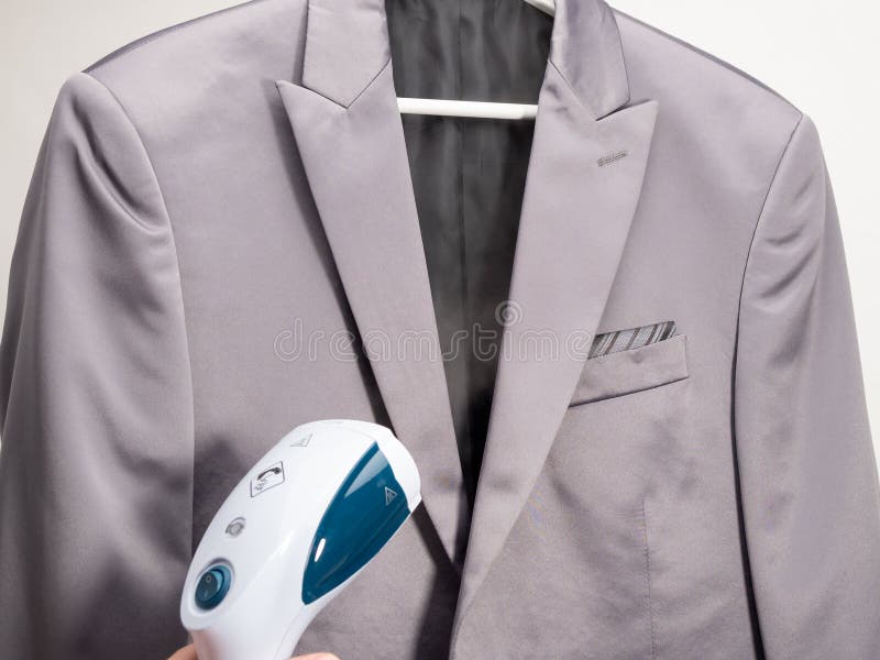 In Hand Steamer for Clothes. the Suit is Ironed with a Portable Iron