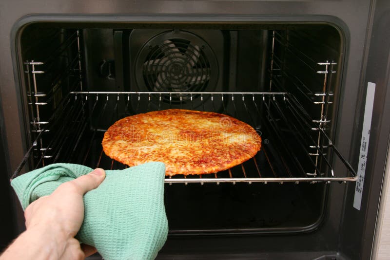 Hand take pizza out of oven