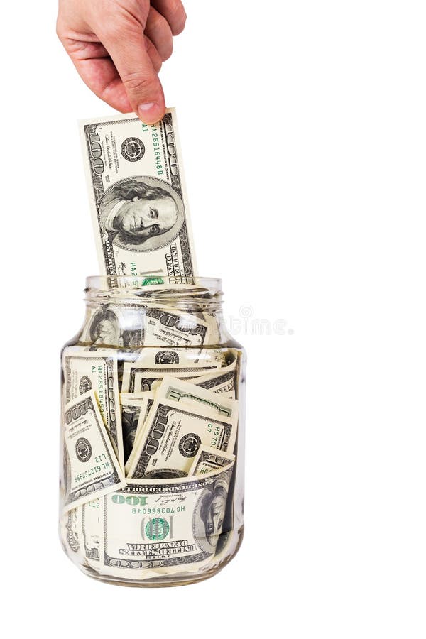 A hand taking hundred US dollars bank notes from a glass jar isolated on white background
