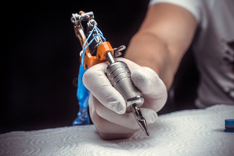 Tattoo Artist with a Tattoo Gun in His Salon Stock Photo Image of