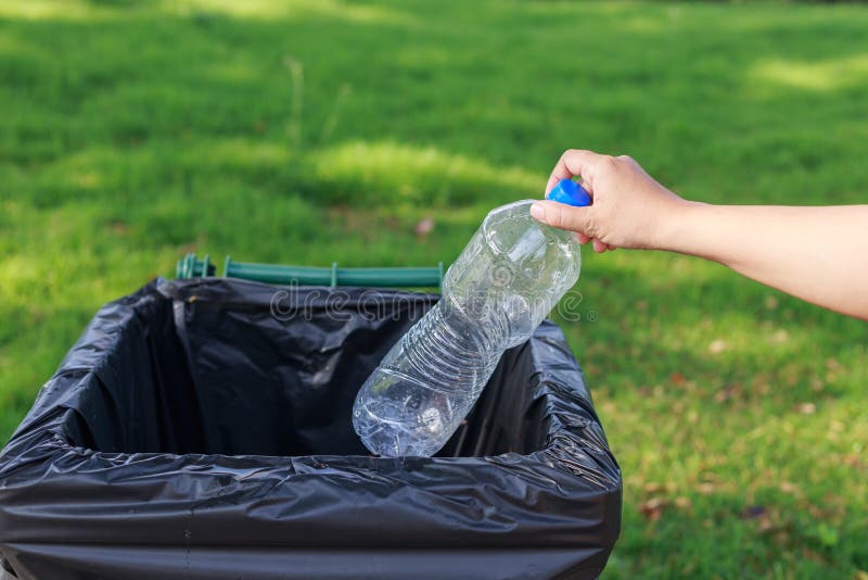Hand throwing empty plastic bottle into the trash royalty free stock photography