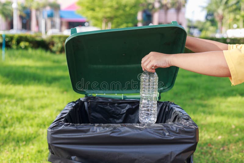 Hand throwing empty plastic bottle into the trash royalty free stock photography