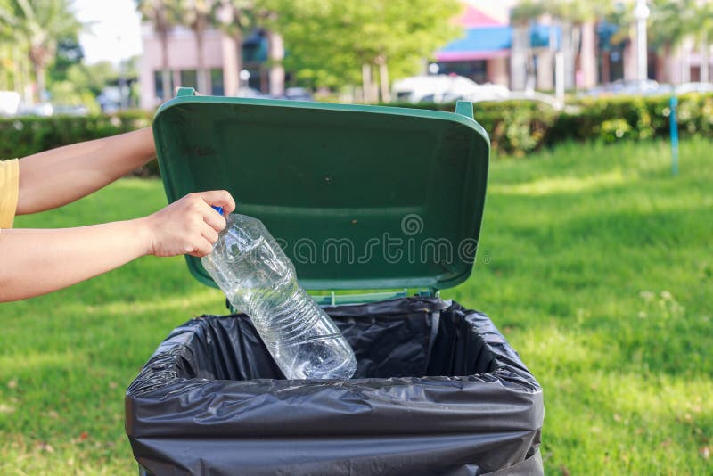 Hand throwing empty plastic bottle into the trash stock photography