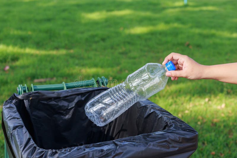 Hand throwing empty plastic bottle into the trash royalty free stock images