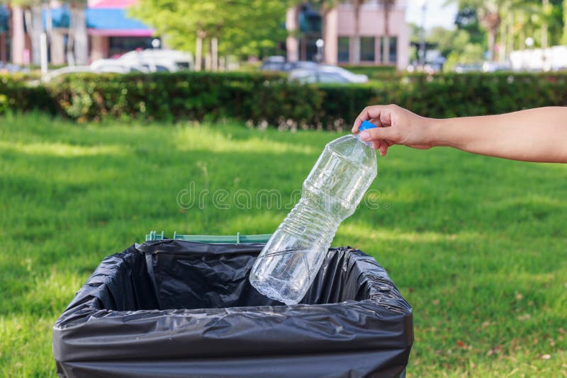 Hand throwing empty plastic bottle into the trash royalty free stock images