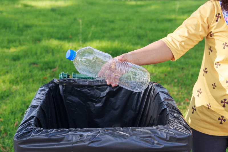 Hand throwing empty plastic bottle into the trash stock images
