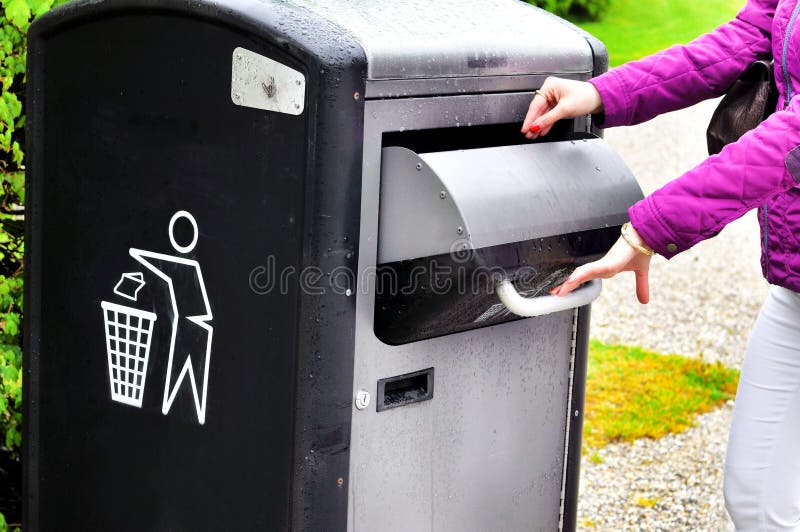 Hand throwing garbage in empty recycling bin royalty free stock photo