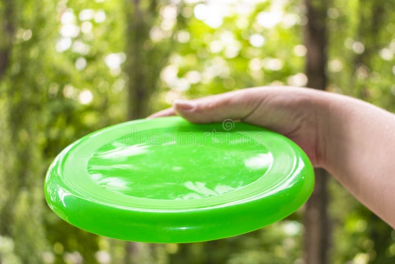Hand Throwing a Frisbee Disc in the Park on a Summer Day Stock Photo