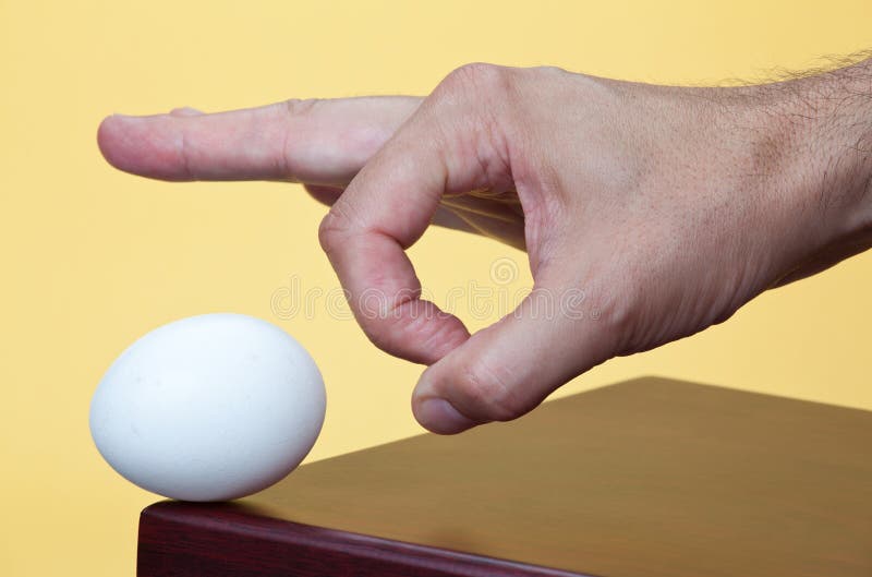 Hand about to flick an egg royalty free stock image