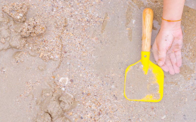 Hand with Toy Shovel Playing on a Wet Sand Beach Stock Photo Image of