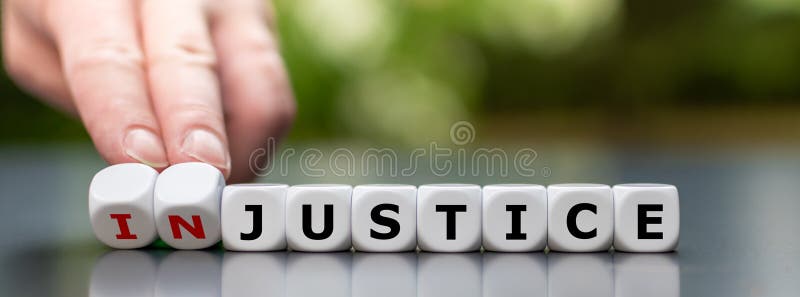 Hand turns dice and changes the word `injustice` to `justice`.