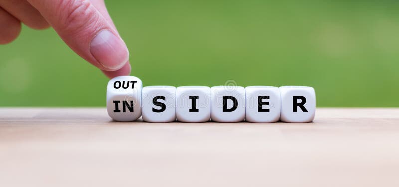 Hand turns a dice and changes the word `OUTSIDER` to `INSIDER` stock images Hand turns a dice and changes the word `OUTSIDER` to `INSIDER` stock images