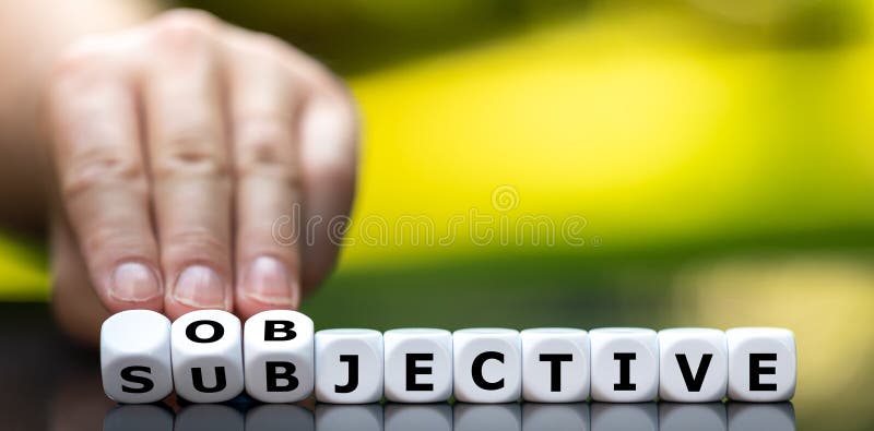 Hand turns dice and changes the word `subjective` to `objective`. royalty free stock photography