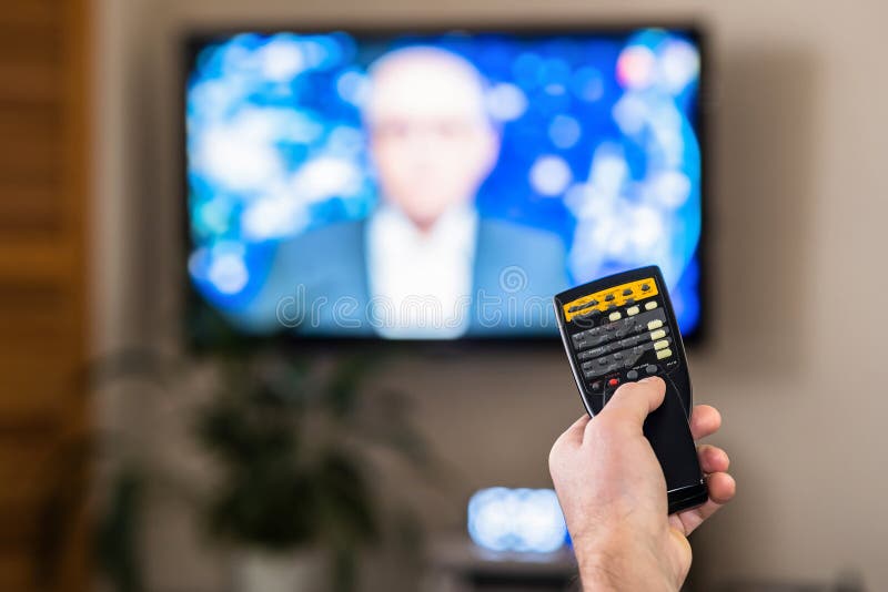 A hand with a TV remote control. The concept of remote communication. Play button icons. Control of the TV& x27;s media player