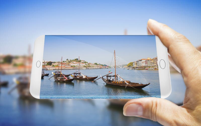 Hand van de man met een smartphone met een foto van een typische portugese boten die in het verleden werden gebruikt voor het ver stock fotografie Hand van de man met een smartphone met een foto van een typische portugese boten die in het verleden werden gebruikt voor het ver stock fotografie