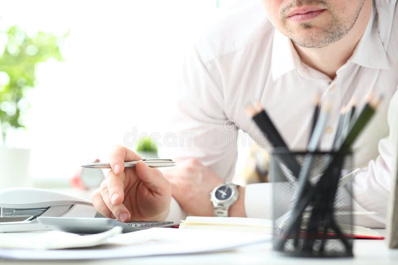 Hand van de mannelijke zilveren pen die van de bediendengreep calculator gebruiken stock afbeelding Hand van de mannelijke zilveren pen die van de bediendengreep calculator gebruiken stock afbeelding