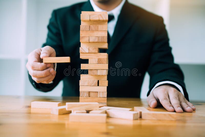 Hand van de stapelsspel van zakenman speelhoutsneden met de planning van strategie van projectleiding stock afbeelding Hand van de stapelsspel van zakenman speelhoutsneden met de planning van strategie van projectleiding stock afbeelding