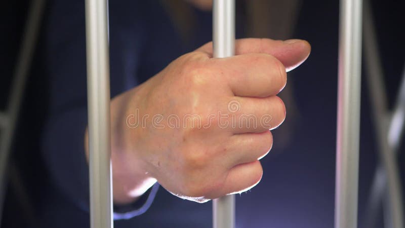 Hand van een gevangene op celbars