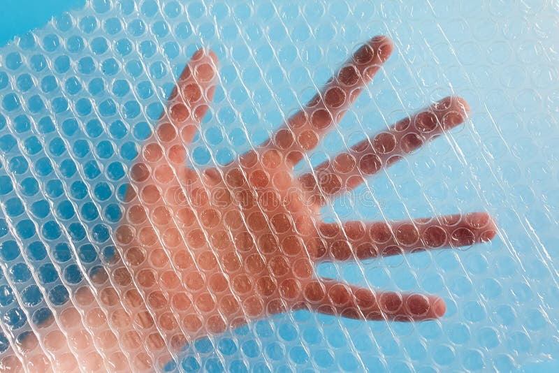 Hand is visible through Bubble Wrap Packing stock photos Hand is visible through Bubble Wrap Packing stock photos