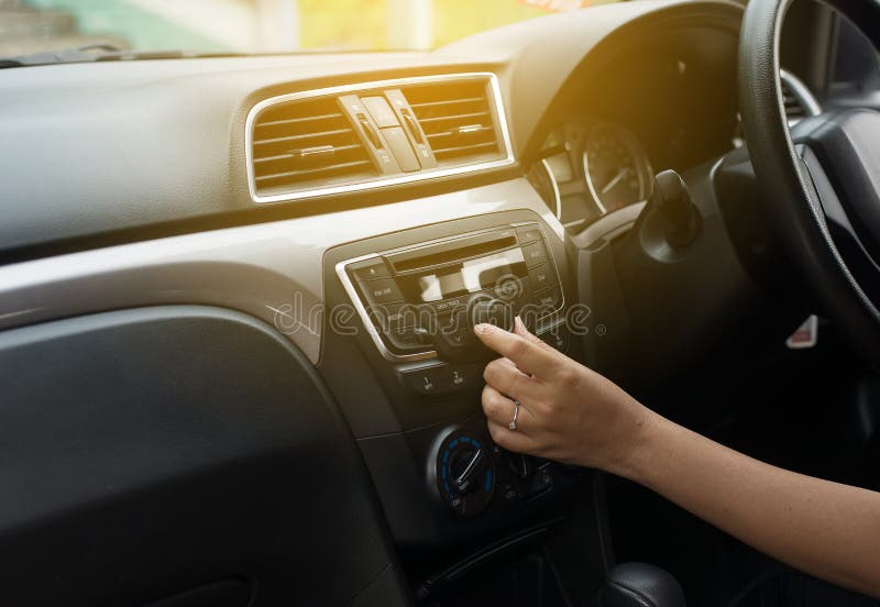 Hand vrouwelijke bestuurder wat betreft het scherm en het aanzetten van het systeem van de autoradio, Knoop op dashboard in autop royalty-vrije stock fotografie Hand vrouwelijke bestuurder wat betreft het scherm en het aanzetten van het systeem van de autoradio, Knoop op dashboard in autop royalty-vrije stock fotografie