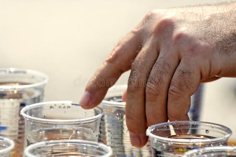 Una vista di una mano che afferra una tazza di acqua.