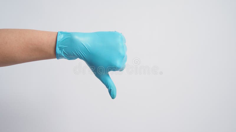 Hand wear surgical glove and doing the thumbs down hand sign on white background. it use when you don`t like something