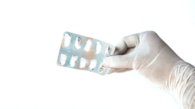 Hand with white latex glove holding an empty blister pack of pills. medical concept royalty free stock photo Hand with white latex glove holding an empty blister pack of pills. medical concept royalty free stock photo